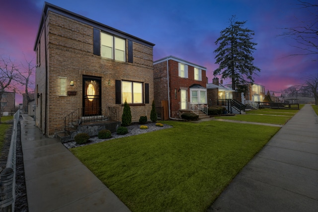 view of front facade with brick siding and a front yard