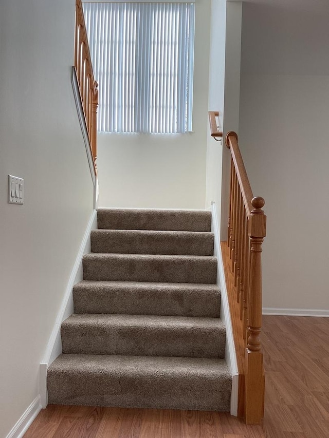 stairway featuring baseboards and wood finished floors