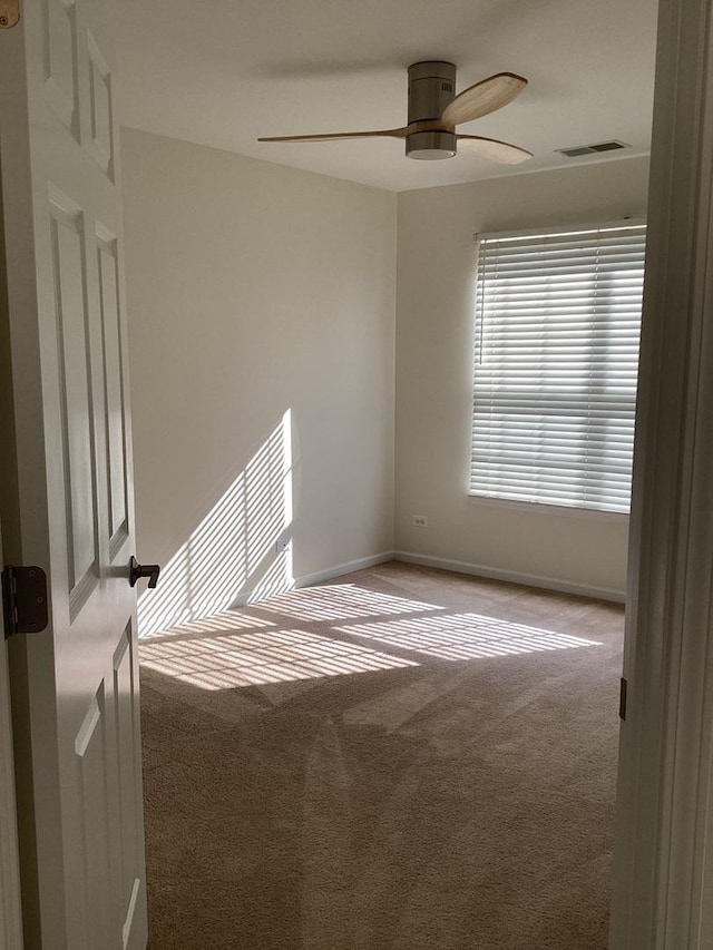 unfurnished room featuring ceiling fan, carpet, visible vents, and baseboards