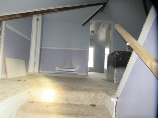 interior space featuring lofted ceiling, carpet, and a baseboard radiator