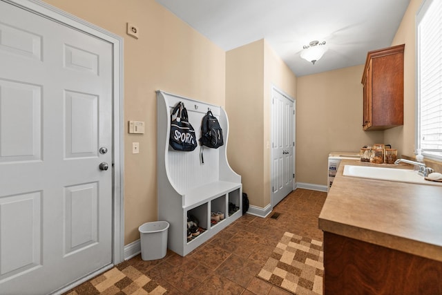 laundry area with visible vents, baseboards, and a sink