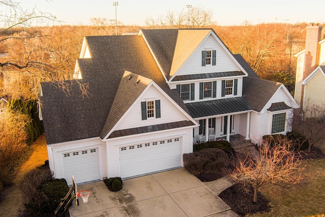 traditional-style home featuring an attached garage, metal roof, and a standing seam roof