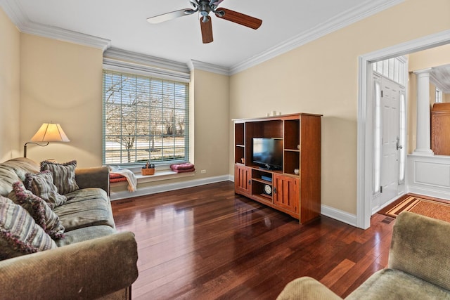 living area featuring wood finished floors, crown molding, decorative columns, baseboards, and ceiling fan