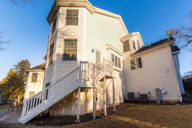 back of property featuring central AC unit, stairs, and a patio