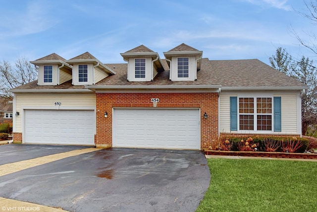 view of front of house with a garage, brick siding, a shingled roof, driveway, and a front yard