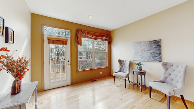 sitting room with recessed lighting, wood finished floors, visible vents, and baseboards