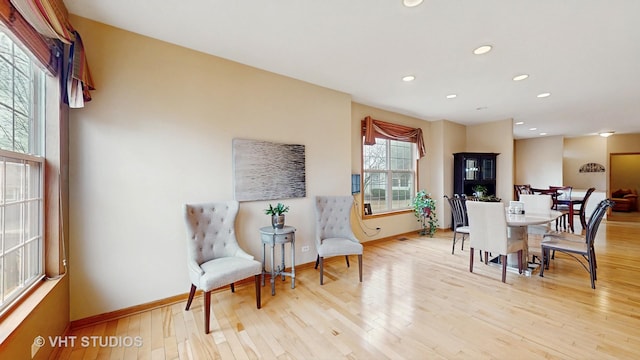 living area with light wood-type flooring, baseboards, and recessed lighting