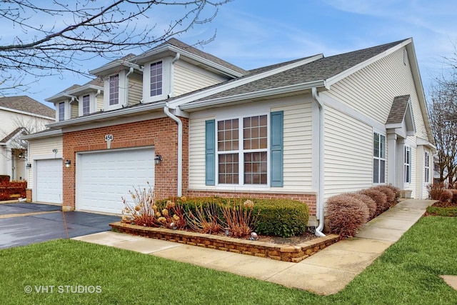 view of side of home featuring driveway, roof with shingles, a garage, and brick siding