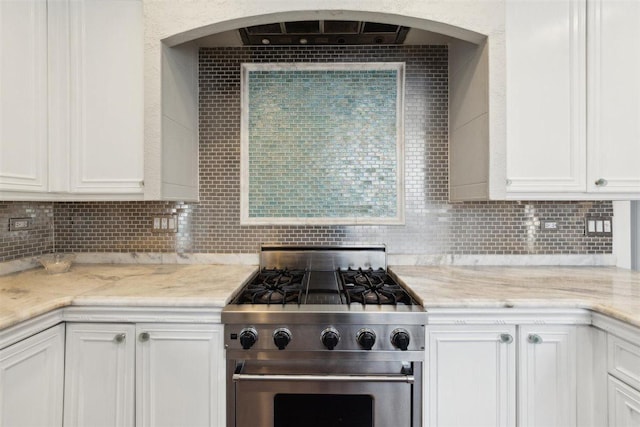 kitchen with white cabinets, light stone countertops, high end range, and decorative backsplash