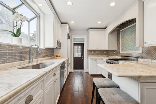 kitchen with dark wood-style floors, recessed lighting, white cabinets, a sink, and dishwasher