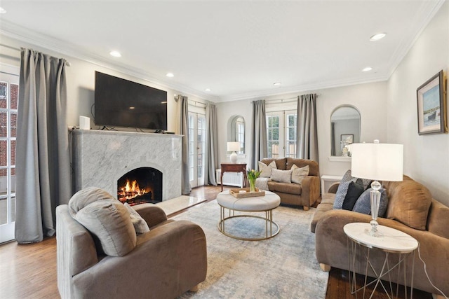 living area with ornamental molding, recessed lighting, a fireplace, and wood finished floors