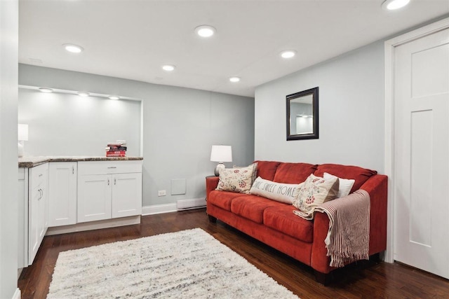 living area with a baseboard heating unit, baseboards, dark wood finished floors, and recessed lighting