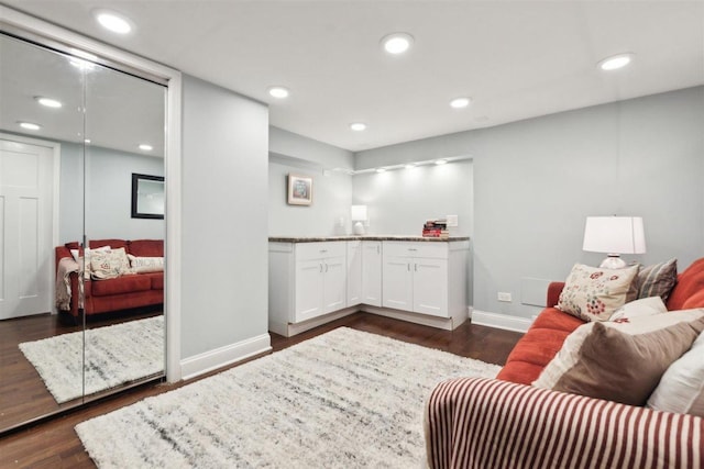 living area featuring baseboards, dark wood-style flooring, and recessed lighting