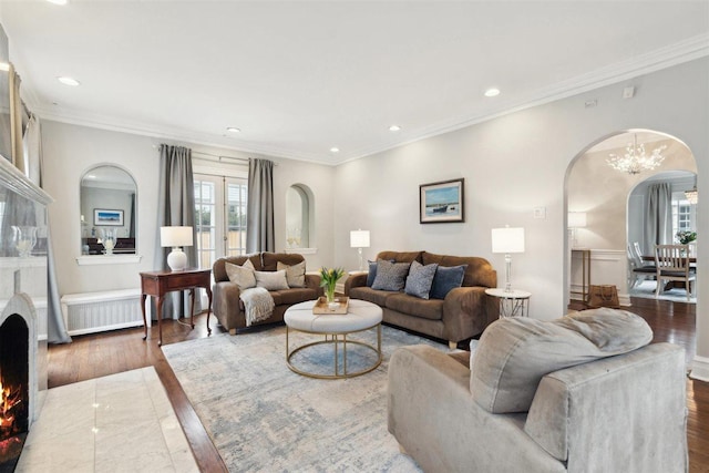 living room with arched walkways, recessed lighting, wood finished floors, radiator, and crown molding