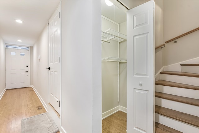 interior space featuring light wood-type flooring, stairway, baseboards, and recessed lighting