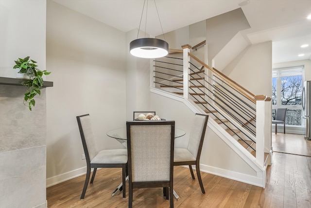 dining room featuring stairs, recessed lighting, wood-type flooring, and baseboards