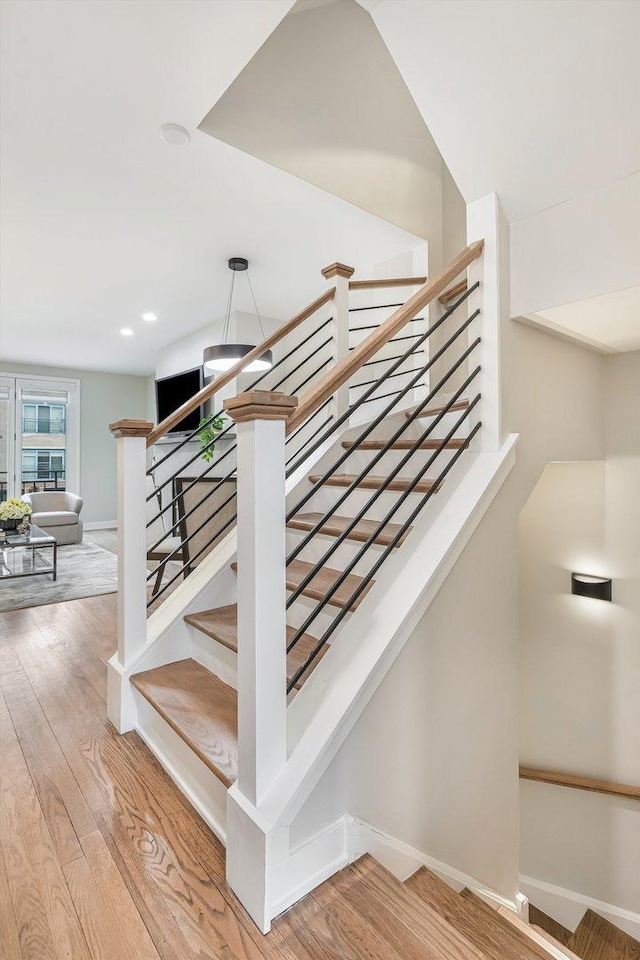 stairway featuring baseboards and wood finished floors