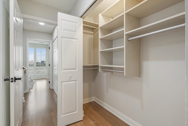 walk in closet with wood finished floors