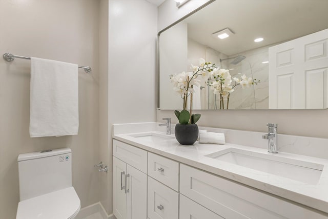 full bathroom featuring tiled shower, a sink, toilet, and double vanity