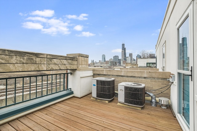 wooden deck featuring cooling unit and a view of city