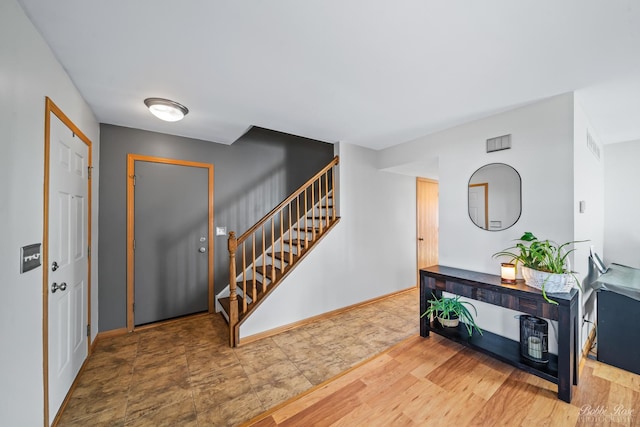 entryway with visible vents, stairs, baseboards, and wood finished floors