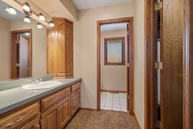 bathroom featuring tile patterned flooring, vanity, and baseboards