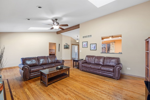 living area with vaulted ceiling with skylight, visible vents, baseboards, ceiling fan, and light wood-type flooring