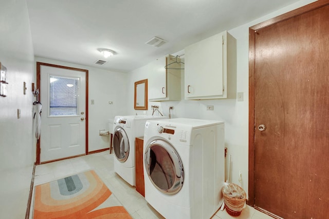 clothes washing area with visible vents, light tile patterned floors, cabinet space, and independent washer and dryer