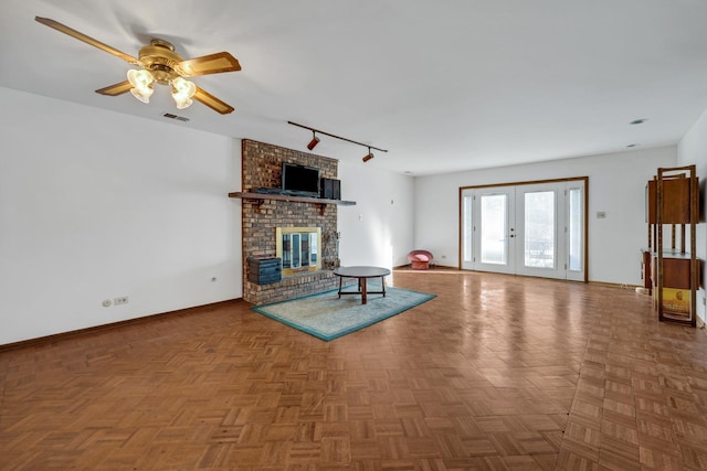 unfurnished living room with a ceiling fan, visible vents, baseboards, french doors, and a brick fireplace