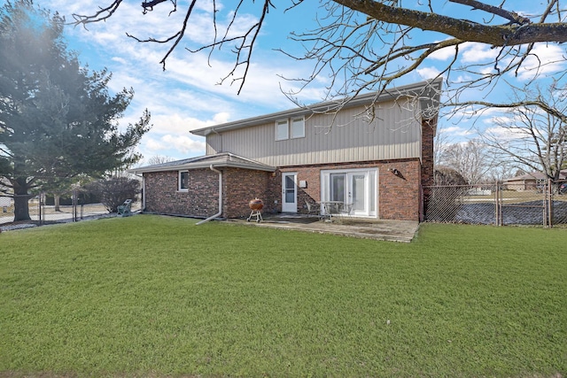 back of house featuring brick siding, a yard, and fence