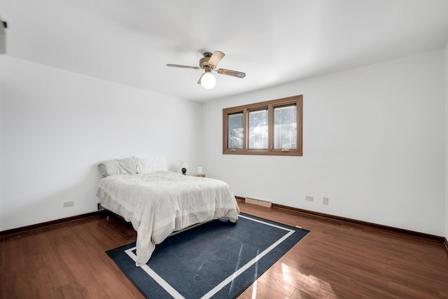 bedroom featuring a ceiling fan, baseboards, and wood finished floors