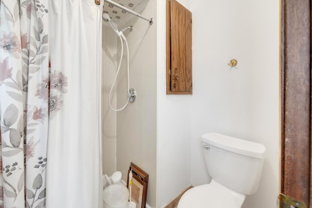 bathroom with a shower with curtain and toilet