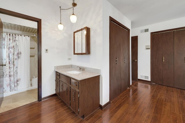 bathroom featuring vanity, a shower with curtain, wood finished floors, and visible vents