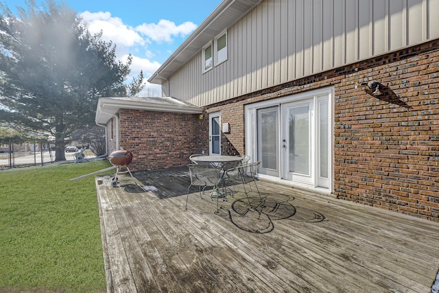 wooden terrace featuring a yard and fence