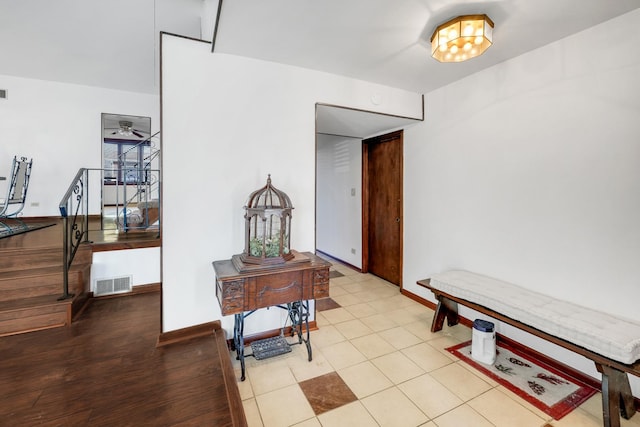 corridor with tile patterned flooring, visible vents, and baseboards