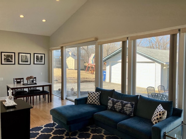 living room featuring light wood-type flooring, high vaulted ceiling, and recessed lighting