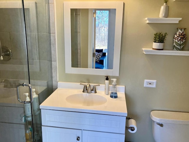 bathroom with a stall shower, vanity, and toilet