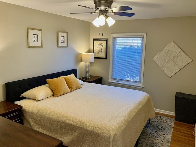 bedroom featuring ceiling fan, wood finished floors, and baseboards