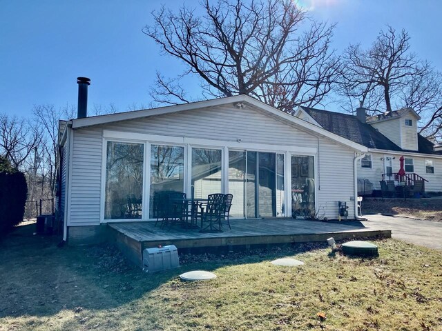 rear view of house with a chimney and a deck