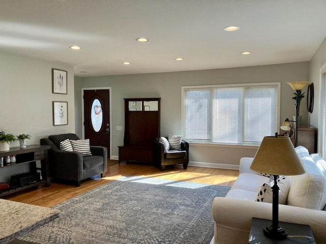 living room featuring baseboards, wood finished floors, and recessed lighting