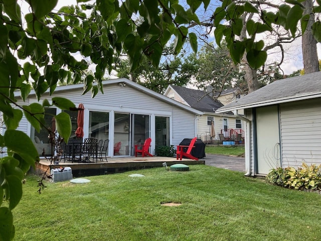 rear view of property featuring a deck and a yard