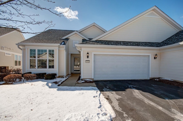 view of front of home featuring an attached garage, driveway, and roof with shingles