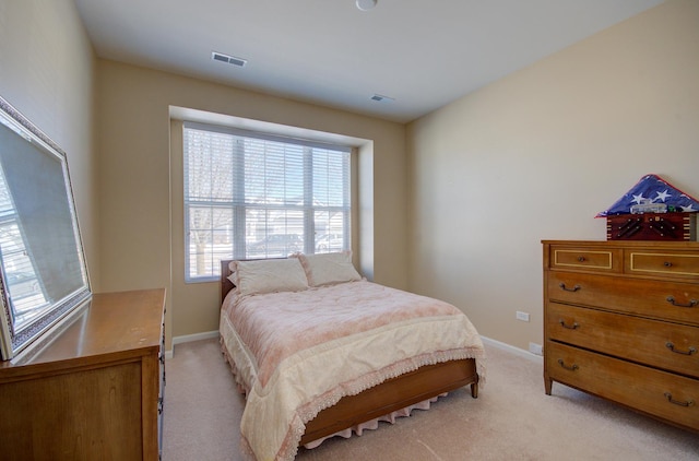 bedroom with baseboards, visible vents, and light carpet