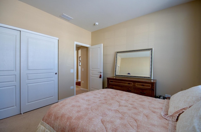 carpeted bedroom featuring a closet and visible vents