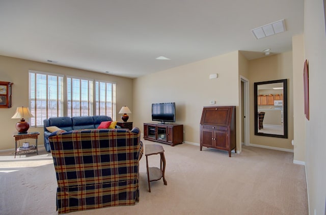 living room featuring visible vents, light carpet, and baseboards