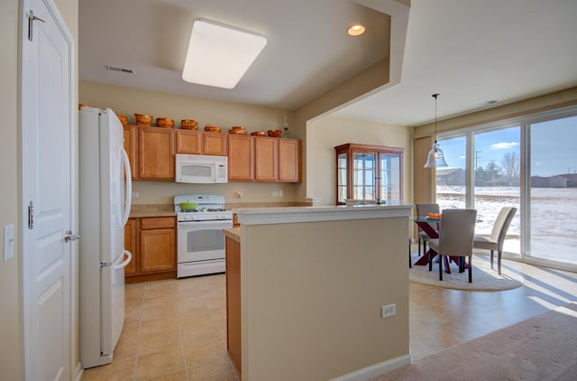 kitchen featuring a center island, decorative light fixtures, light countertops, recessed lighting, and white appliances