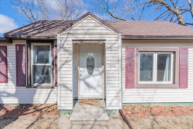 property entrance featuring roof with shingles