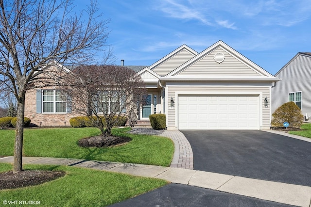 ranch-style home with driveway, brick siding, an attached garage, and a front yard