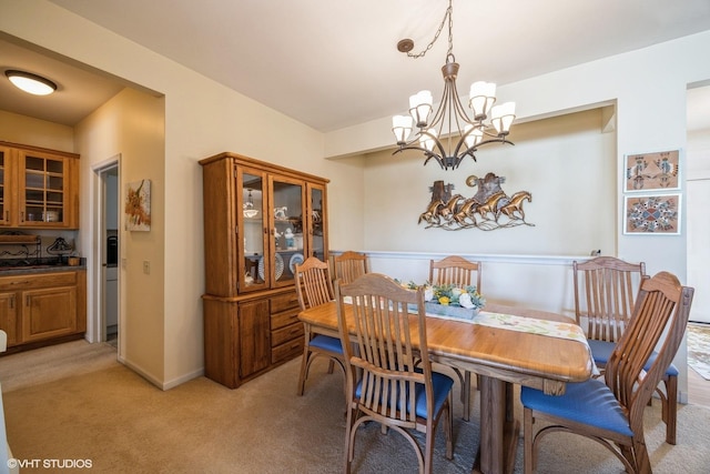 dining space with light carpet, baseboards, and an inviting chandelier