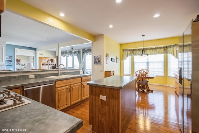 kitchen featuring recessed lighting, a sink, appliances with stainless steel finishes, a center island, and dark wood-style floors